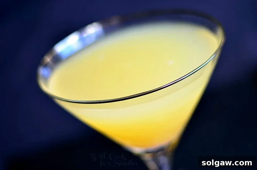 Above photo of Pineapple Champagne Martini in a martini glass with a cherry in the bottom, ready to be enjoyed.