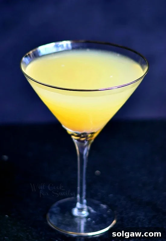 Pineapple Champagne Martini in a martini glass on a clean background, highlighting its color and clarity.