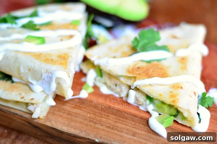 Sliced Avocado Chicken Quesadilla arranged beautifully on a wood cutting board, showcasing its golden-brown exterior and delicious filling.