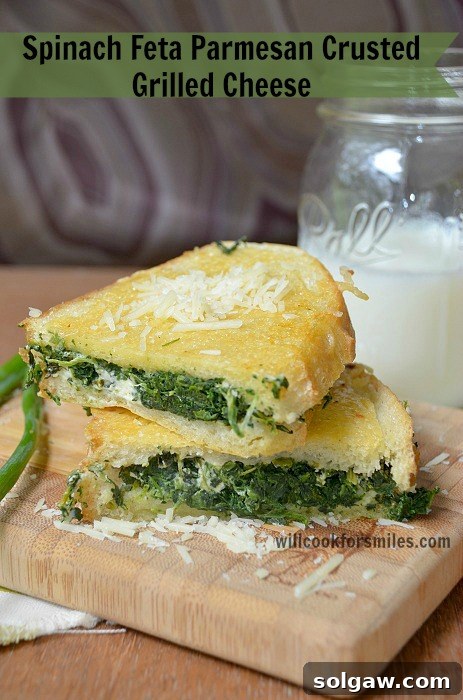 Spinach Feta Parmesan Crusted Grilled Cheese sandwich on a cutting board, showing its crispy, cheesy crust.