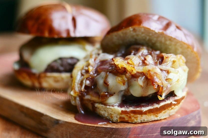 Close-up of a juicy Buffalo Burger on a pretzel bun, topped with luscious Caramelized Onions and glossy Demi Glace, ready to be enjoyed.