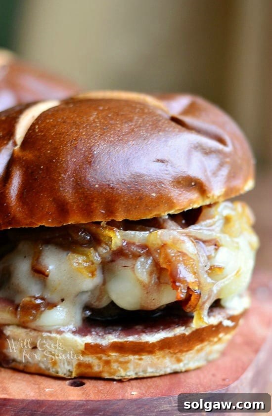 Overhead shot of a decadent Buffalo Burger with caramelized onions and a rich demi-glace, sitting on a rustic wooden surface.