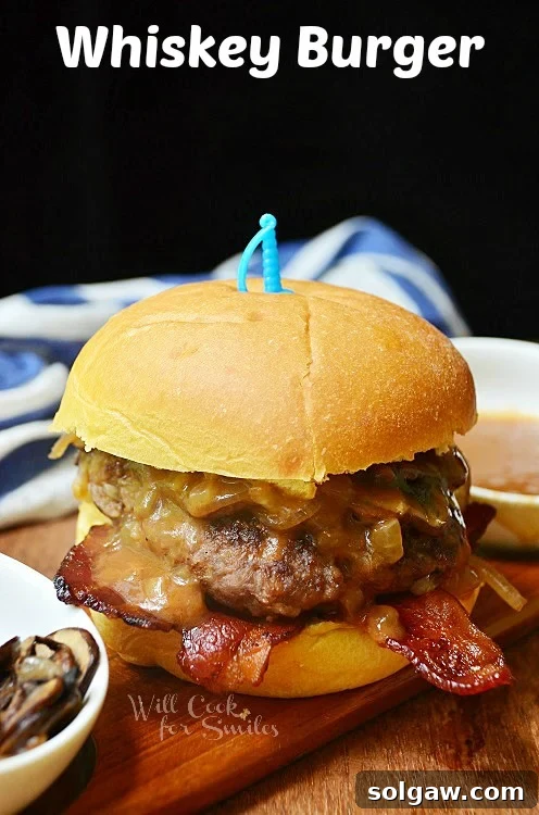 Hearty Whiskey Burger with a bun, served on a rustic wood cutting board.