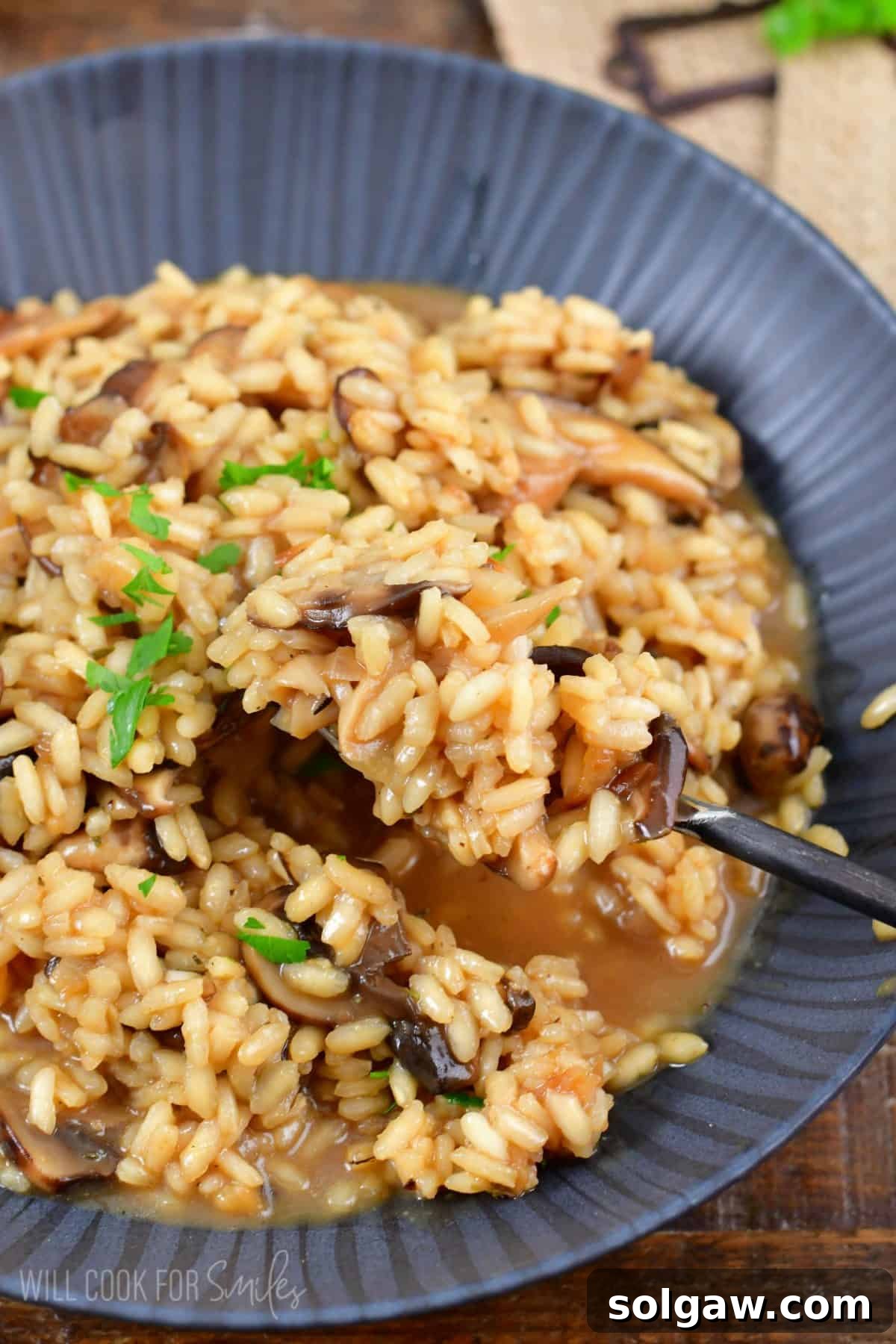 mushroom risotto in a bowl with a fork scooping it out.