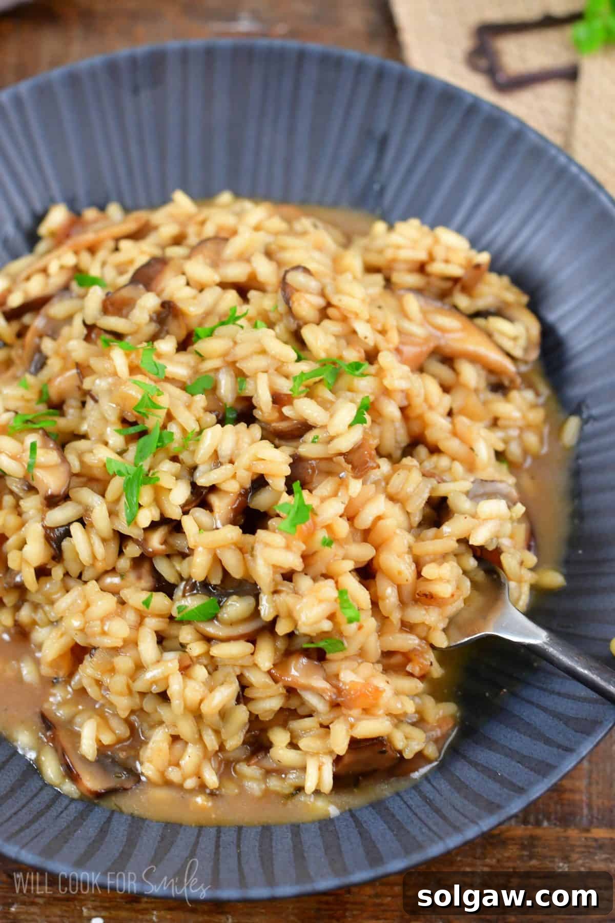 mushroom risotto in a bowl with a fork scooping some up.