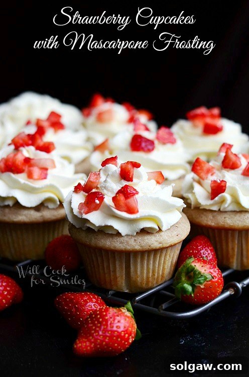 Velvety Marble Cupcakes with Swirled Cream Cheese Frosting 9 Strawberry Cupcakes topped with delicate mascarpone frosting, surrounded by fresh strawberries on a cooling rack.