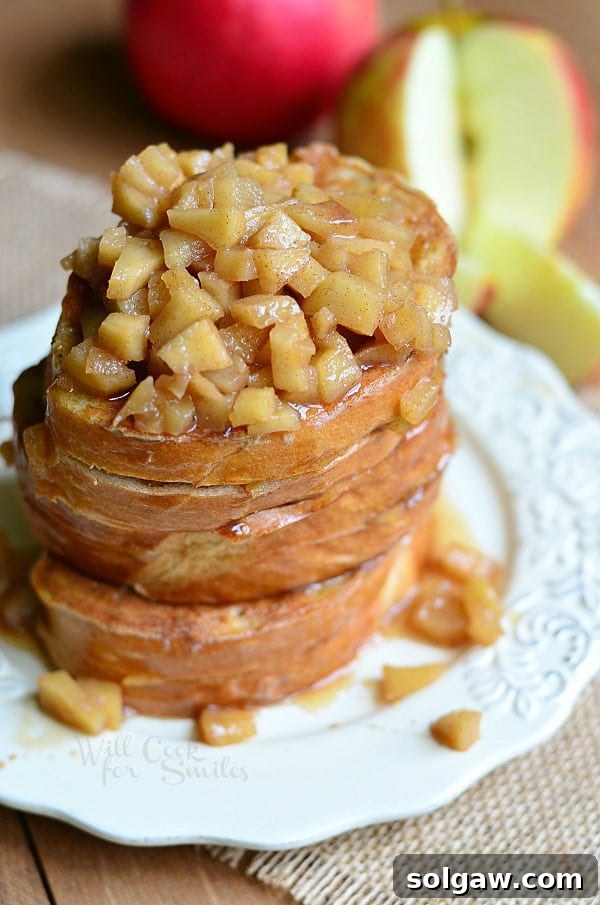 Spiced Apple Pie French Toast 12 Top down view of Apple Pie Stuffed French Toast on a plate with cinnamon sticks and a fork