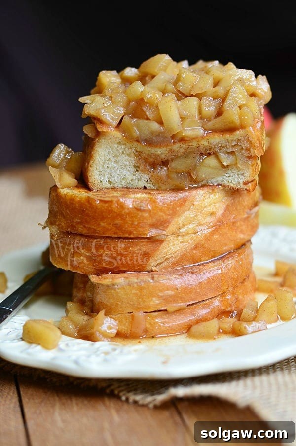 Spiced Apple Pie French Toast 3 Close-up of three slices of Apple Pie Stuffed French Toast stacked on a plate with a fork, ready to be enjoyed