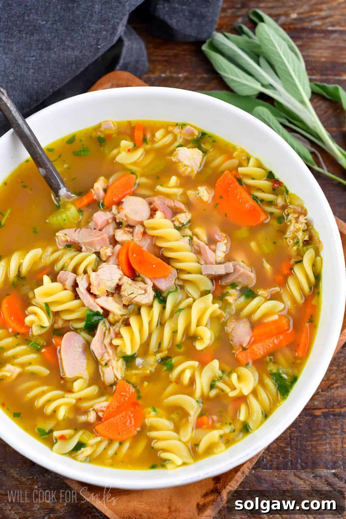 Leftover turkey noodle soup served hot with fresh parsley and sage in a flavorful homemade turkey broth.