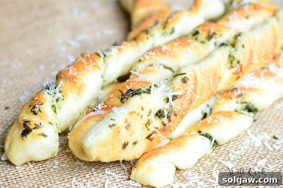 Homemade Parmesan Garlic & Herb Breadsticks on a baking sheet, ready to be served.