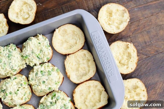 Several bottom slider buns, some are filled and some are not, with some inside taken out.
