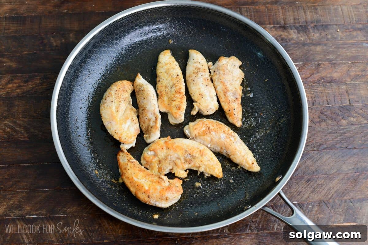 Seasoned chicken tenderloins cooked in a skillet until lightly browned for jalapeño ranch chicken sliders.