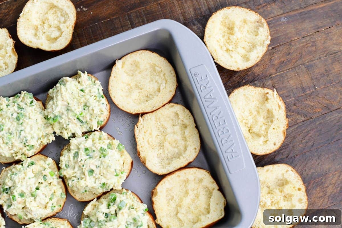 Several bottom slider buns, some are filled and some are not, with some inside taken out to prevent sogginess.