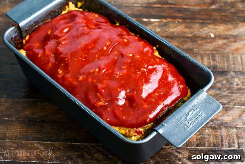Turkey meatloaf in a loaf pan fully baked and topped with a thick, glossy ketchup glaze.