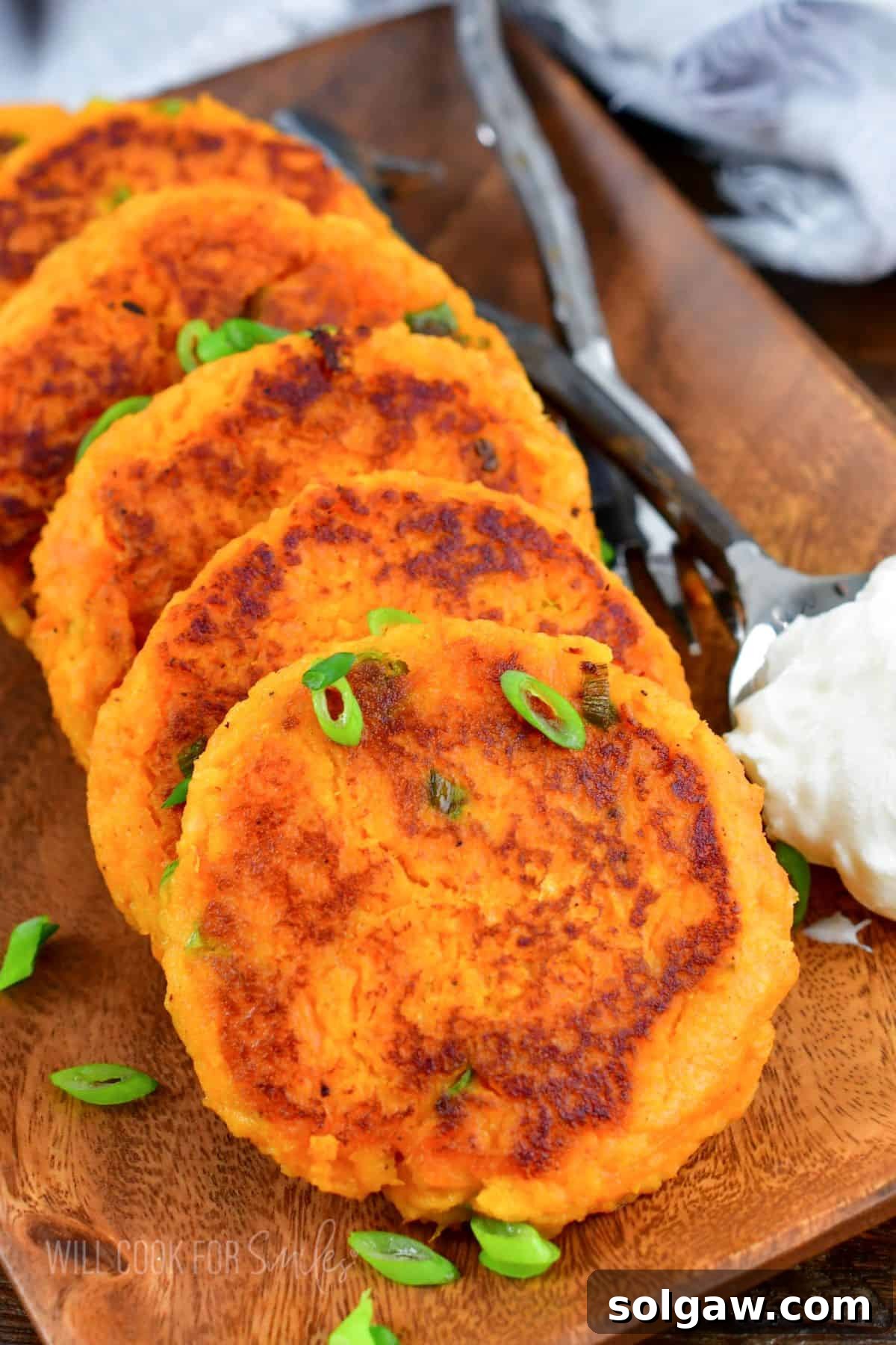 A batch of sweet potato cakes are garnished with green onions. 