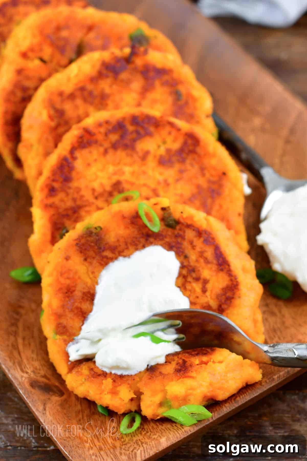 A fork is digging into a sour cream topped sweet potato cake. 