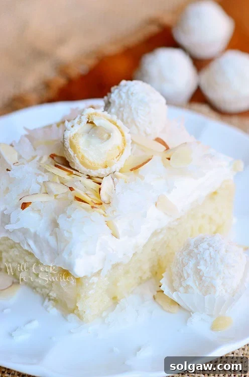Raffaello Poke Cake - a moist coconut cake with white chocolate-coconut cream and whipped topping.