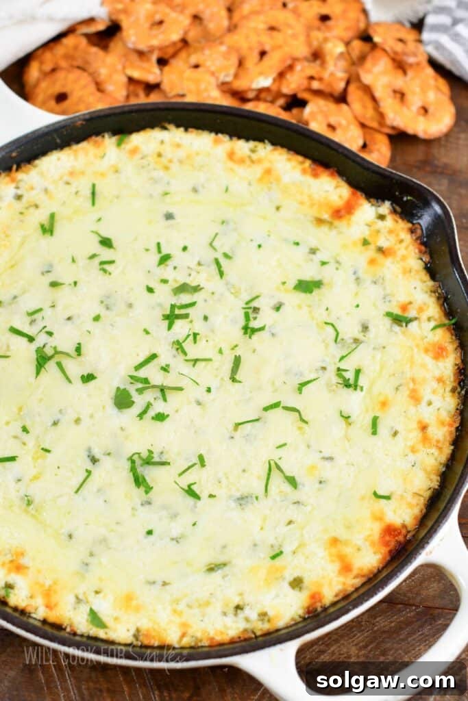 top view of baked four cheese dip served with pretzels in a skillet, ready for a party.