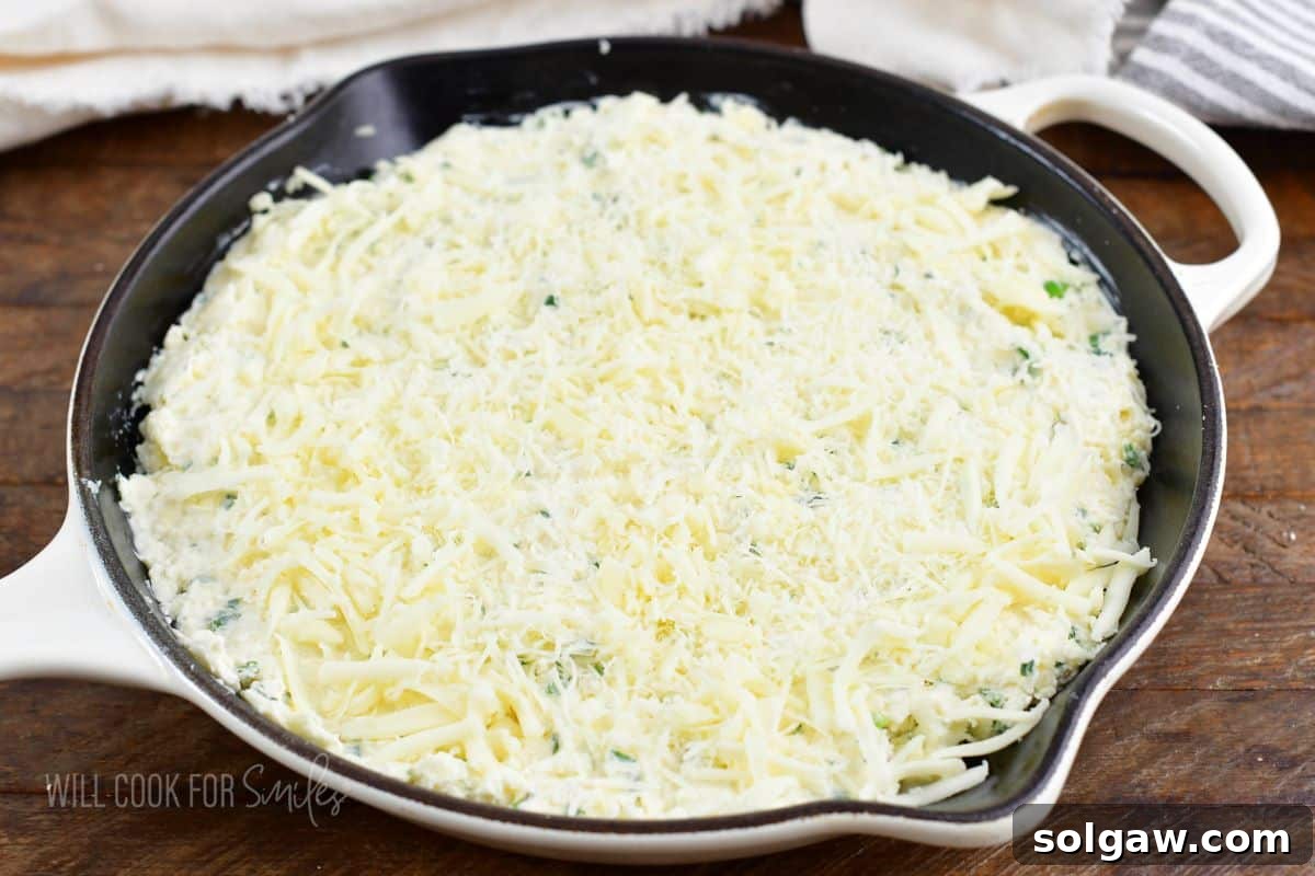 four cheese dip spread evenly in a skillet before baking.