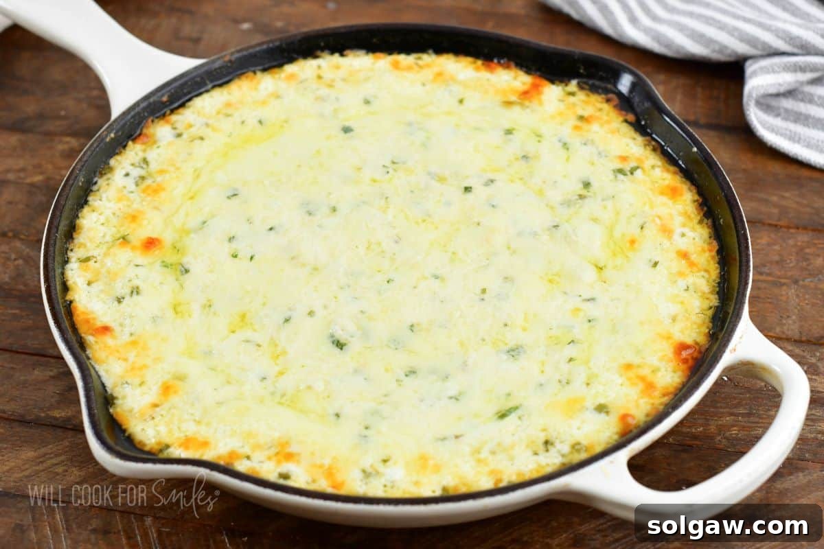 baked four cheese dip bubbling and golden in a skillet, fresh from the oven.