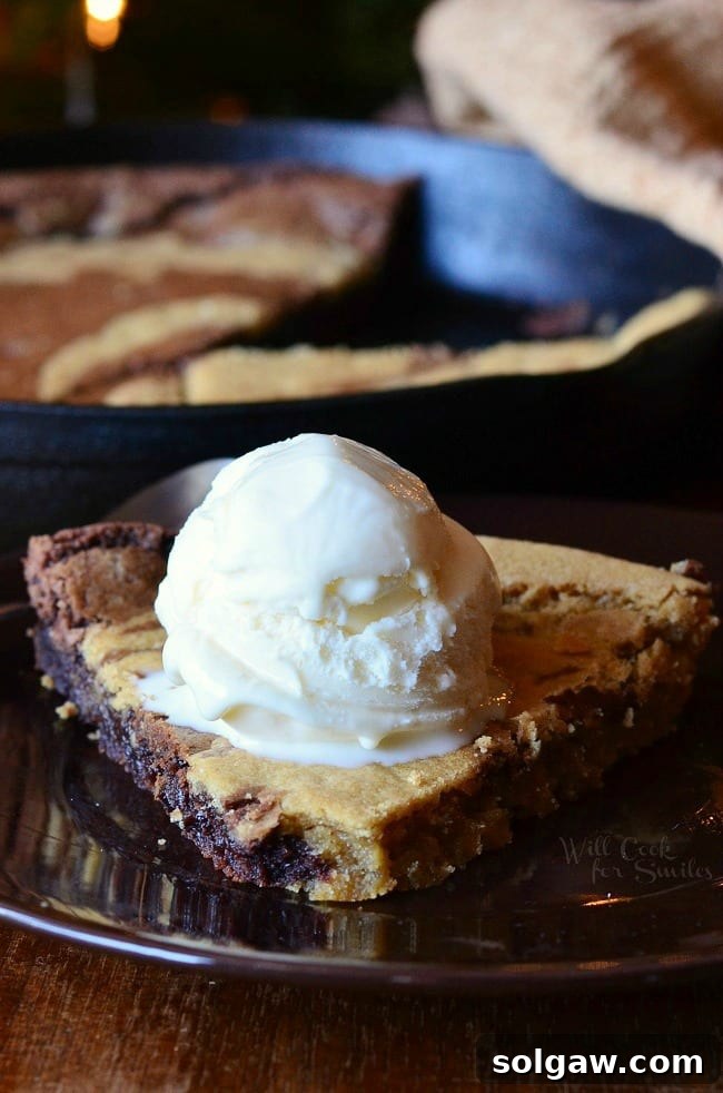 Dreamy Vanilla Bean Swirl Skillet 6 A large skillet cookie topped with multiple scoops of vanilla ice cream, served directly from the pan, inviting sharing.