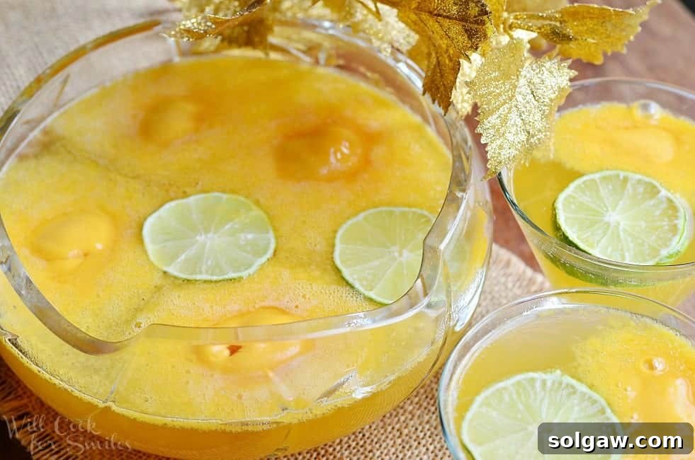 Decorative wine glass filled with champagne sorbet punch on a burlap placemat with a bowl filled with punch to the left