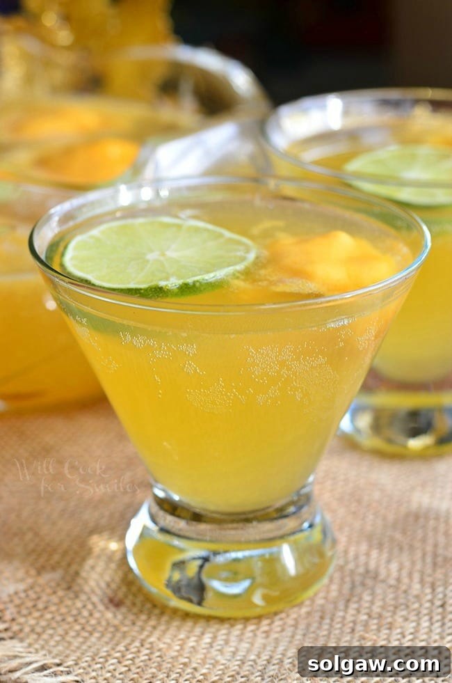 A close-up of a glass of Champagne Sorbet Punch, showing the delicate bubbles and the melting sorbet, creating a visually appealing layer of flavors.