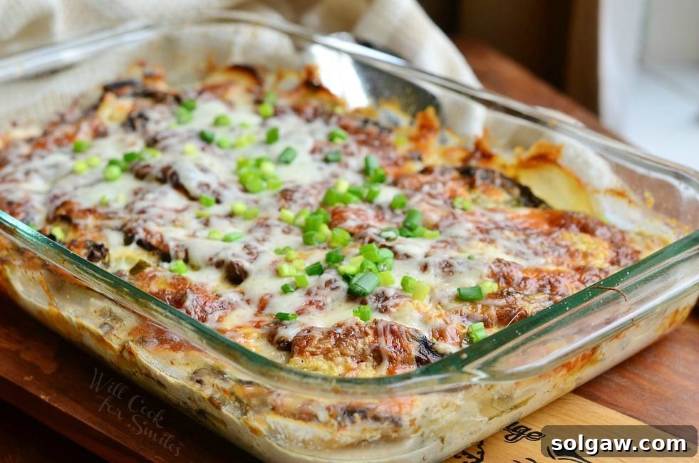 Scalloped Potatoes Au Gratin with green onions on top in a glass baking dish 