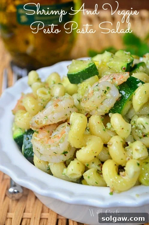 shrimp and veggie pesto pasta salad in a white bowl 