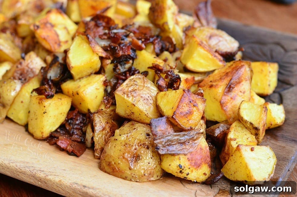 Roasted Potatoes with Bacon and Pearl Onions on a wood cutting board