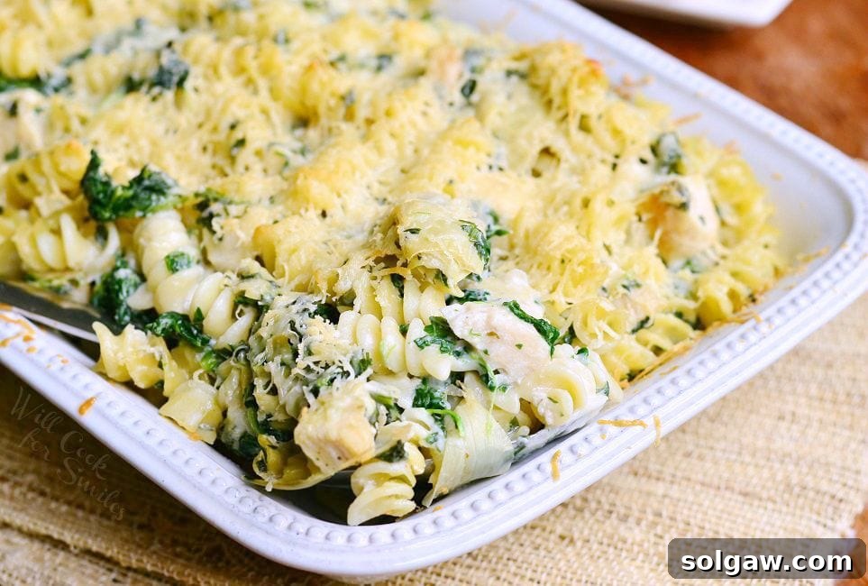 Chicken Spinach and Artichoke Pasta served in a white casserole dish.
