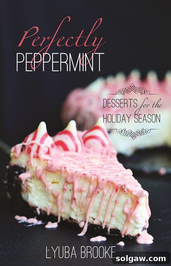Peppermint cheesecake with peppermint kisses around the outside with peppermint and white chocolate dripped over the top 