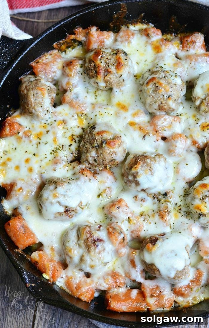 Hearty Meatball Gnocchi Casserole 7 top view photo of Meatball and Gnocchi Bake with cheese on top in a cast iron skillet, golden and bubbly