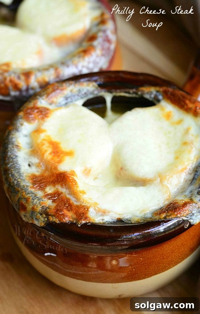 Philly Cheese Steak Soup cheese on top in a soup bowl 