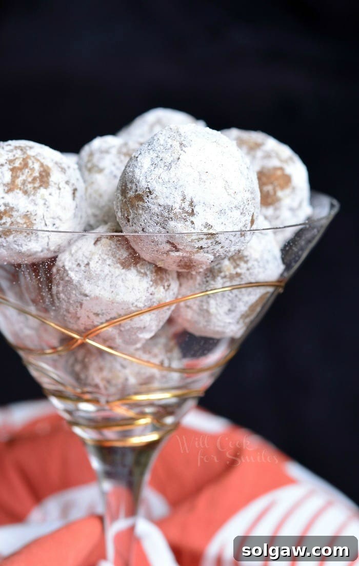 Pumpkin Spice Rum Balls with powder sugar on the outside of them in a champagne glass