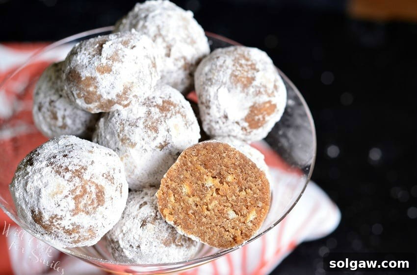 Pumpkin Spice Rum Balls with powder sugar on the outside of them and one with half missing in a champagne glass