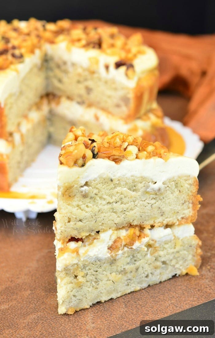 A delightful slice of Caramel Banana Nut Cake displayed on a rustic wooden table, with the full cake subtly blurred in the background