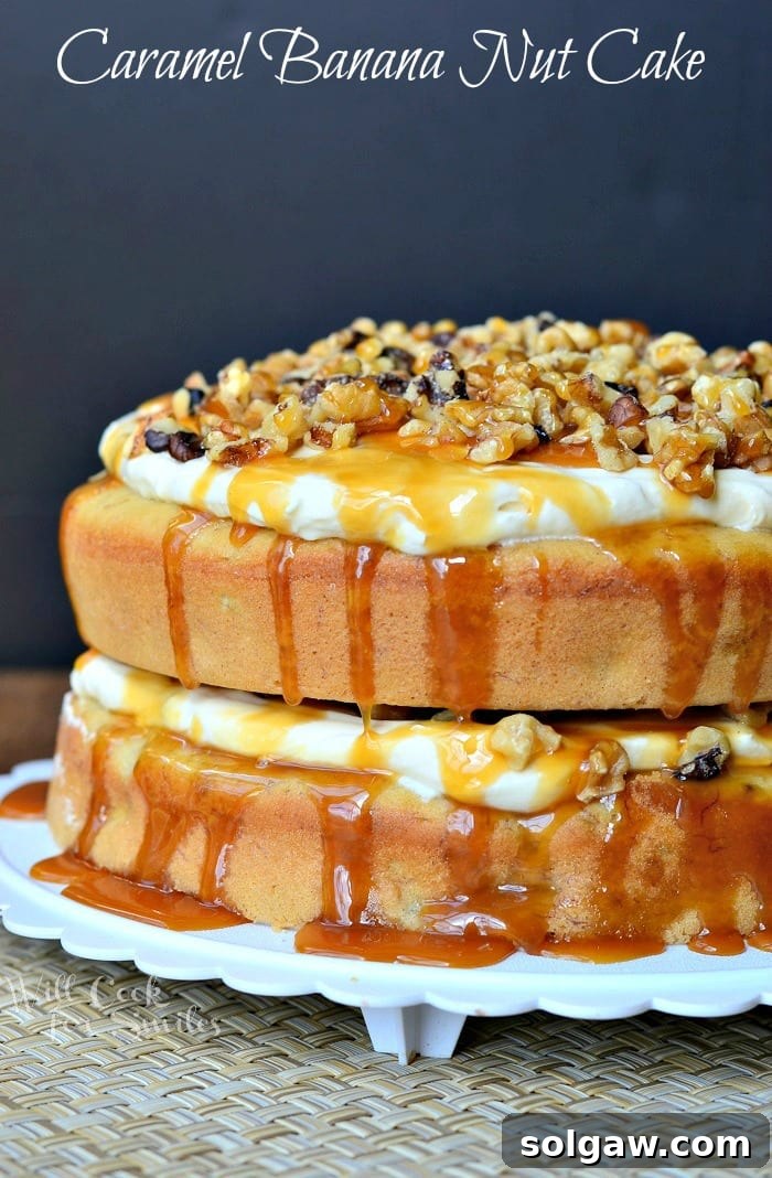 A stunning whole Caramel Banana Nut Cake on a beautiful cake platter, generously topped with chopped walnuts and drizzled caramel