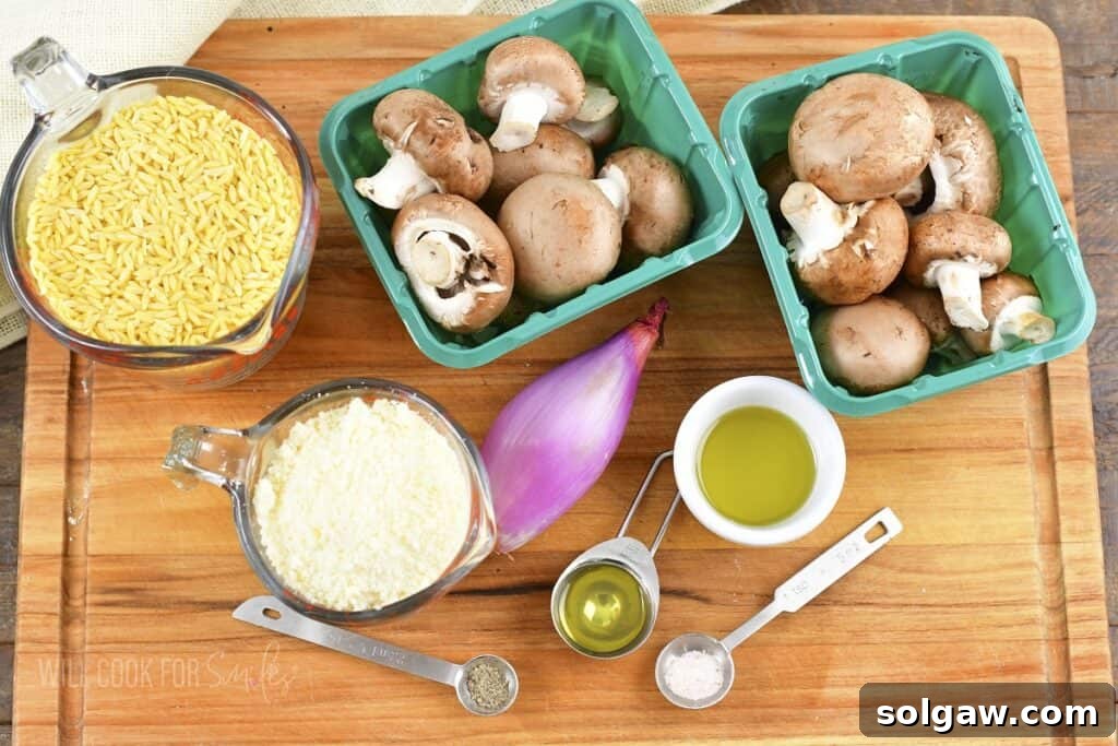 ingredients to make parmesan mushroom orzo laid out on a cutting board, including fresh mushrooms, shallots, and Parmesan.