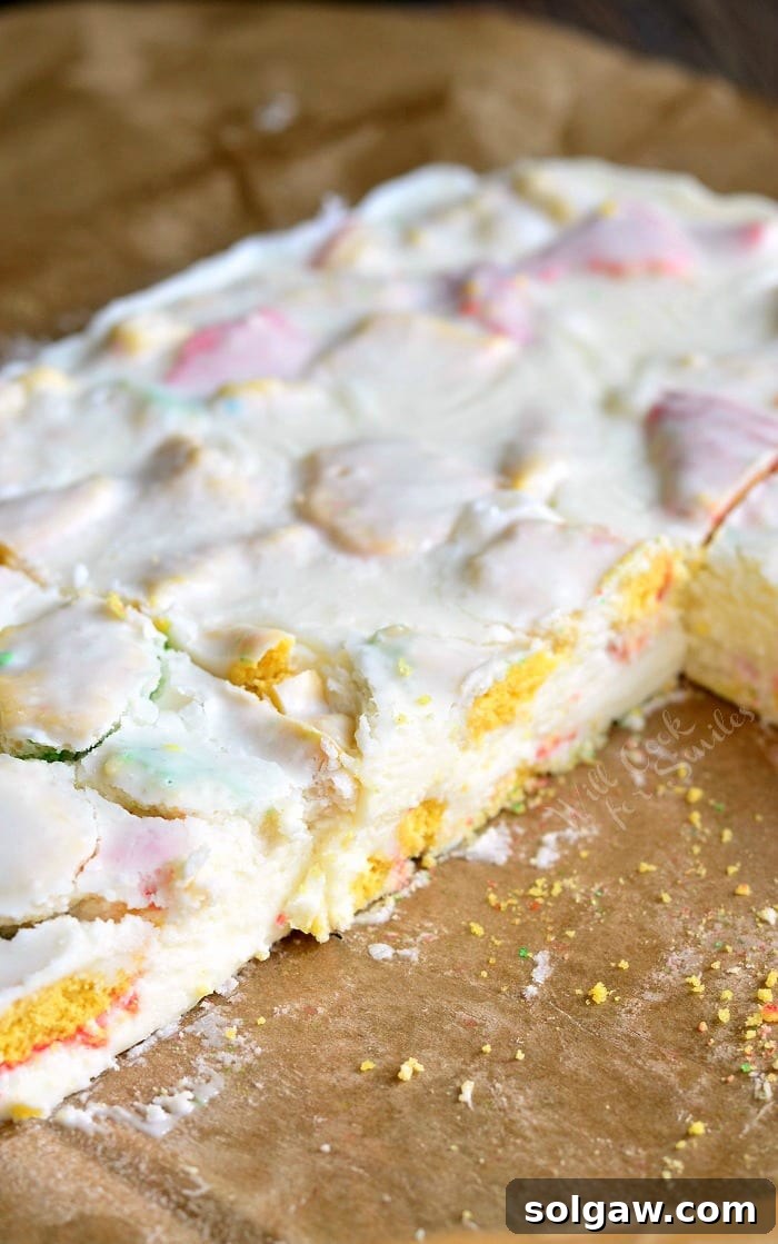 Sugar Cookie Fudge on parchment paper with some pieces cut out