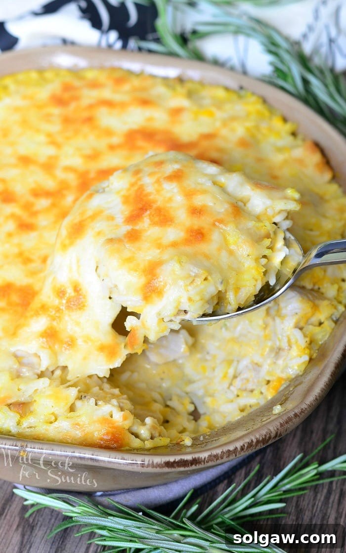 Turkey, Butternut Squash, and Mascarpone Rice Casserole in a baking dish with a spoon scooping some out, revealing its rich interior