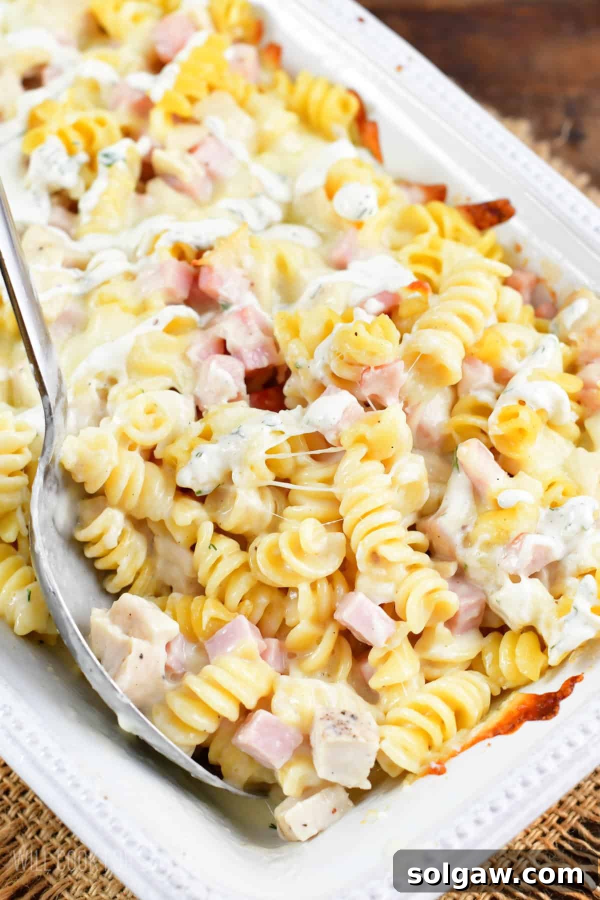 Chicken Cordon Bleu Chicken Casserole being mixed up with a spoon.