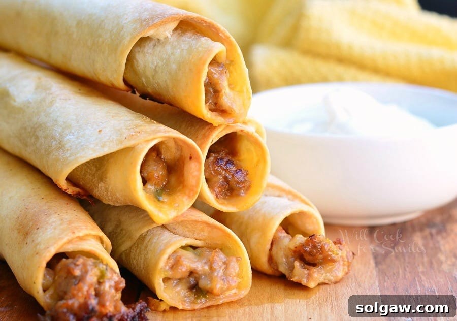 Jalapeño Sausage and Cheese Taquitos stacked on a cutting board