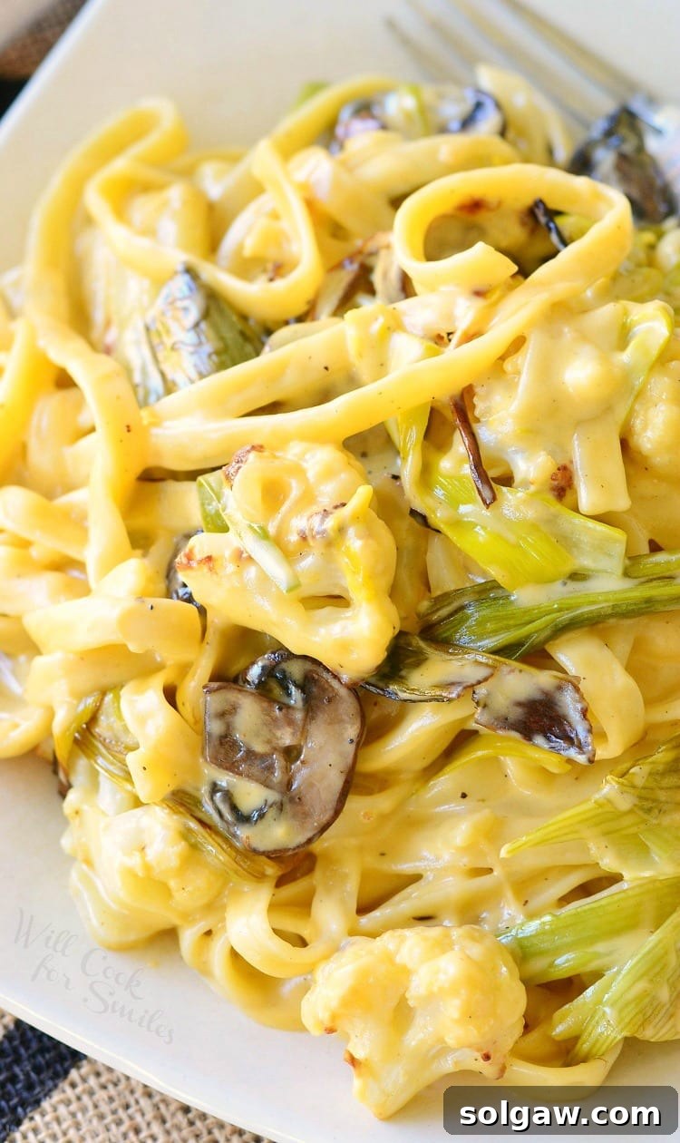 Close-up of Cauliflower, Leek, and Mushroom Fettuccine in a creamy Garlic Cheese Sauce, served in a rustic white bowl.