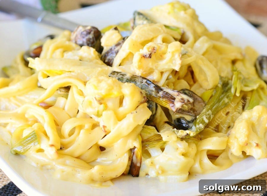 A generous serving of Cauliflower, Leek, and Mushroom Fettuccine in Garlic Cheese Sauce, presented in a wide, shallow bowl, ready to be enjoyed.