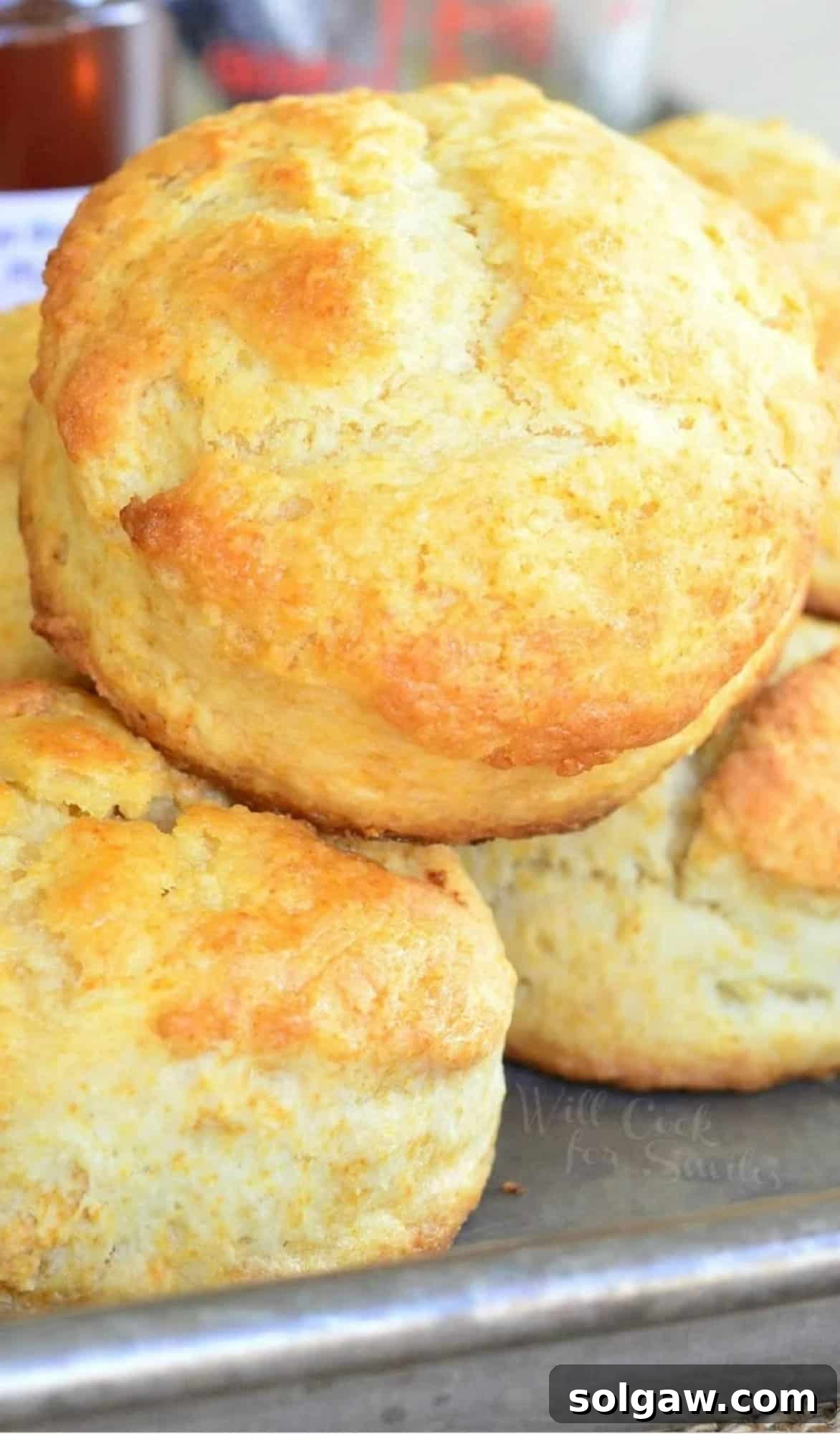 honey butter biscuits stacked on a baking sheet.