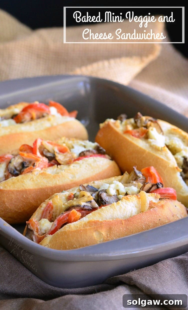 Baked Mini Veggie and Cheese Sandwiches arranged neatly on hoagie rolls in a baking pan, ready to serve.