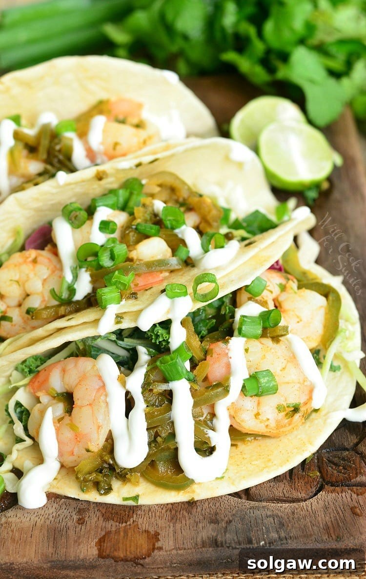 Top view of tequila Lime Shrimp Tacos with sour cream and green onions on top