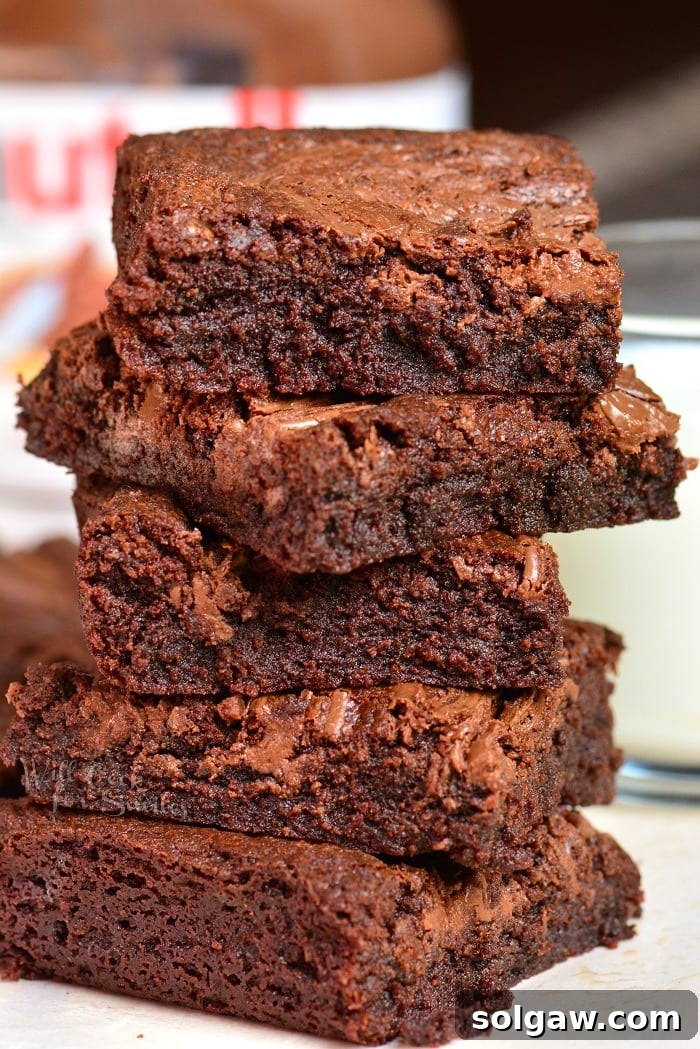 five Nutella brownies stacked up on a piece of parchment paper, showing the top swirl.