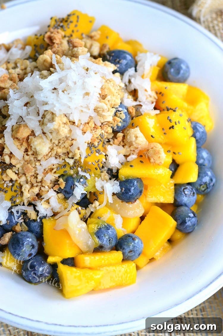 White bowl filled with mango lychee and blueberry fruit bowl as viewed from above
